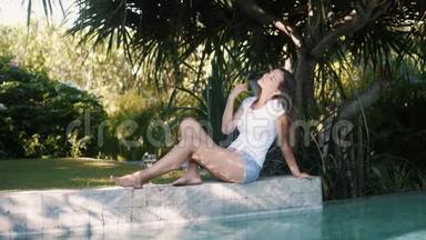 穿着休闲<strong>夏装</strong>的女人坐在泳池边，休息享受假期